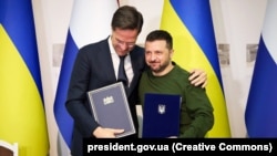 Ukrainian President Volodymyr Zelenskiy (right) and Dutch Prime Minister Mark Rutte pose for photographers after signing a cooperation agreement in Kharkiv on March 1. 
