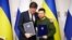 Ukrainian President Volodymyr Zelenskiy (right) and Dutch Prime Minister Mark Rutte pose for photographers after signing a cooperation agreement in Kharkiv on March 1. 
