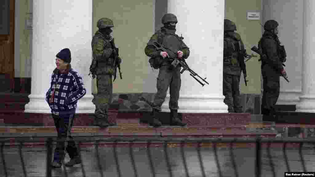 Jelzés nélküli egyenruhát viselő orosz katonák a szimferopoli repülőtér előtt 2014. február 28-án. Az orosz katonák az egész Krímben megjelentek. A lakosság &bdquo;kis zöld emberekként&rdquo;&nbsp;kezdett hivatkozni rájuk, mert nem volt rajtuk sem rang-, sem országjelzés. A Kreml kezdetben azt állította, hogy a katonák helyi önvédelmi csoportok tagjai, de később elismerte, hogy hivatásos oroszok