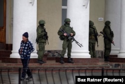 Російські «зелені чоловічки» біля будівлі аеропорту в Сімферополі. 28 лютого 2014 року. Анексія Криму почалась під час зимової Олімпіади в російському Сочі