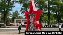 Persoane pozând cu steaua roșie de Ziua Victoriei la Tiraspol (imagine de arhivă)
