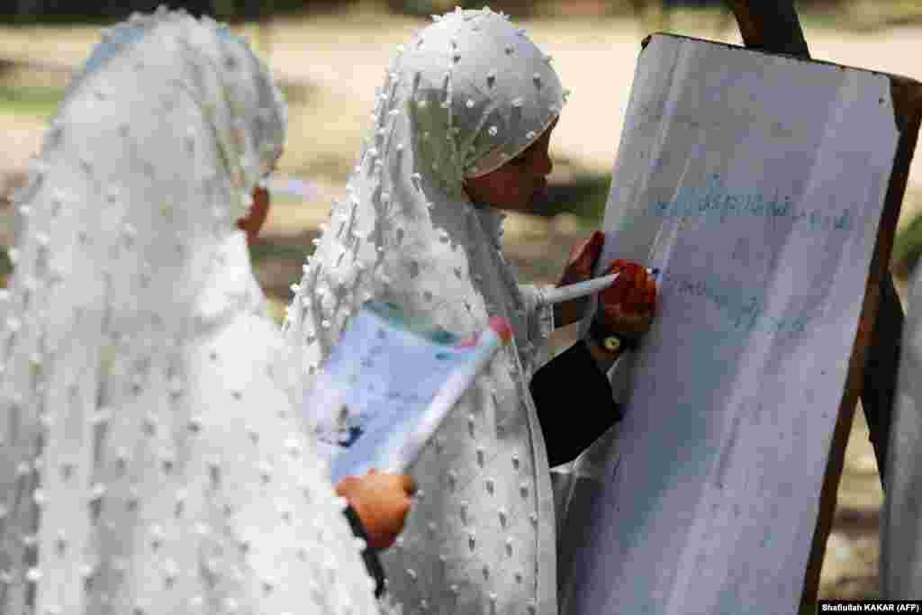 Afghan schoolgirls attend a class at an open-air primary school in Jalalabad.