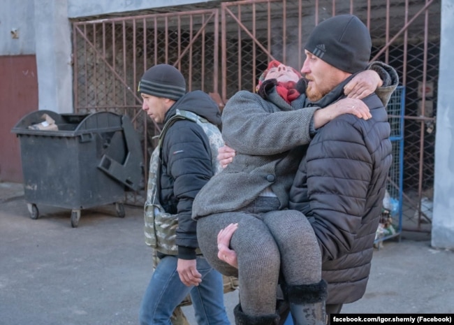 Ігор Чорний під час евакуації виносить жінку на руках