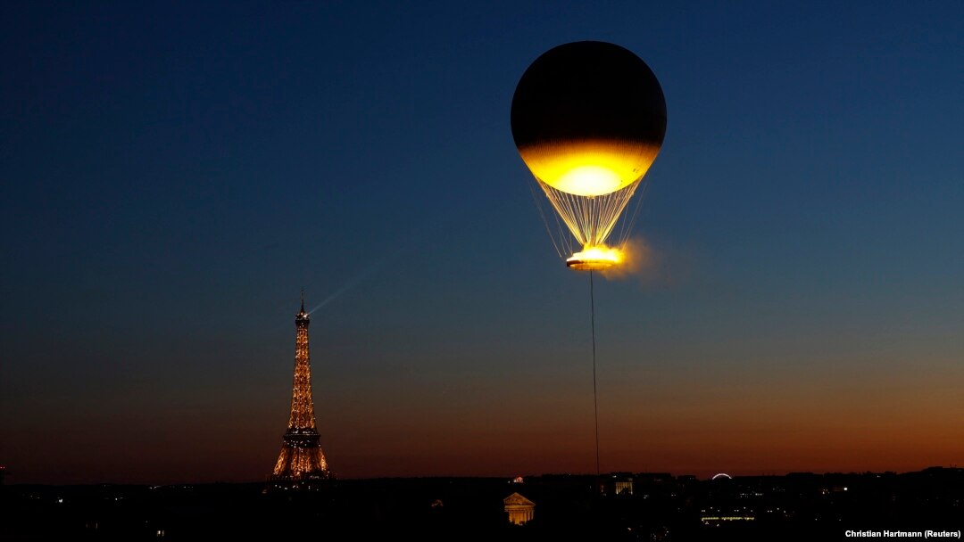 Flacăra olimpică în timp ce zboară deasupra Parisului, atașată de un balon.