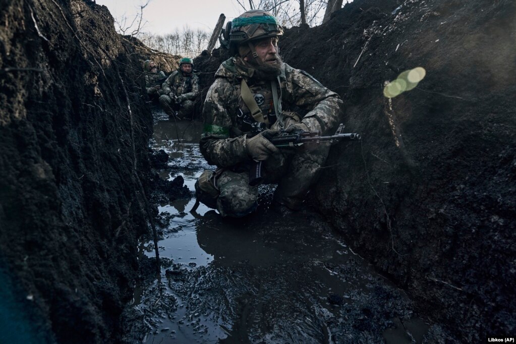 Ushtarët ukrainas, të cilët u caktuan për mbrojtjen e qytetit, janë duke banuar në llogore të përmbytura me baltë.