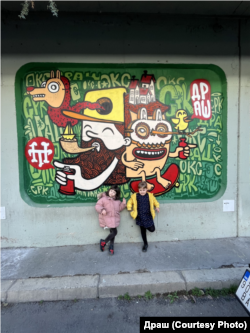 Ќерките на Драш и Мачка пред делото на Драш во Градскиот трговски центар (ГТЦ), направено во 2018