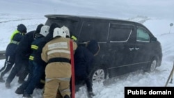 Спасатели извлекают автомобиль из снежного заноса