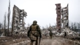 Российские военные приближаются к разрушенному жилому дому в Авдеевке, городе в Донецкой области Украины.<br />
<br />
Фото снято 22 февраля. Это один из первых снимков Авдеевки после захвата города российскими войсками