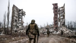 Російські військові біля руїн житлового будинку у захопленій Авдіївці Донецької області, 22 лютого 2024 року