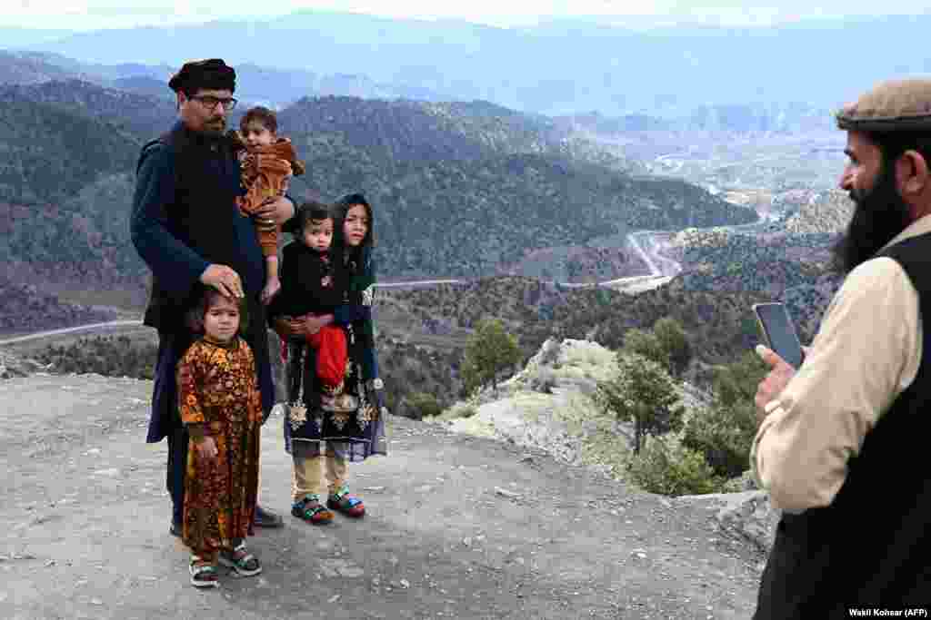 A man takes a picture of a family with a mobile phone on a hilltop on the outskirts of Gardez, Paktia Province, Afghanistan.