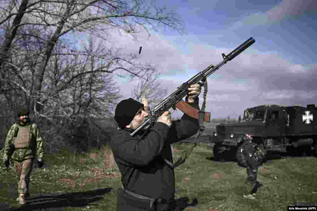 A Ukrainian soldier fires his rifle at a drone.&nbsp; &nbsp;