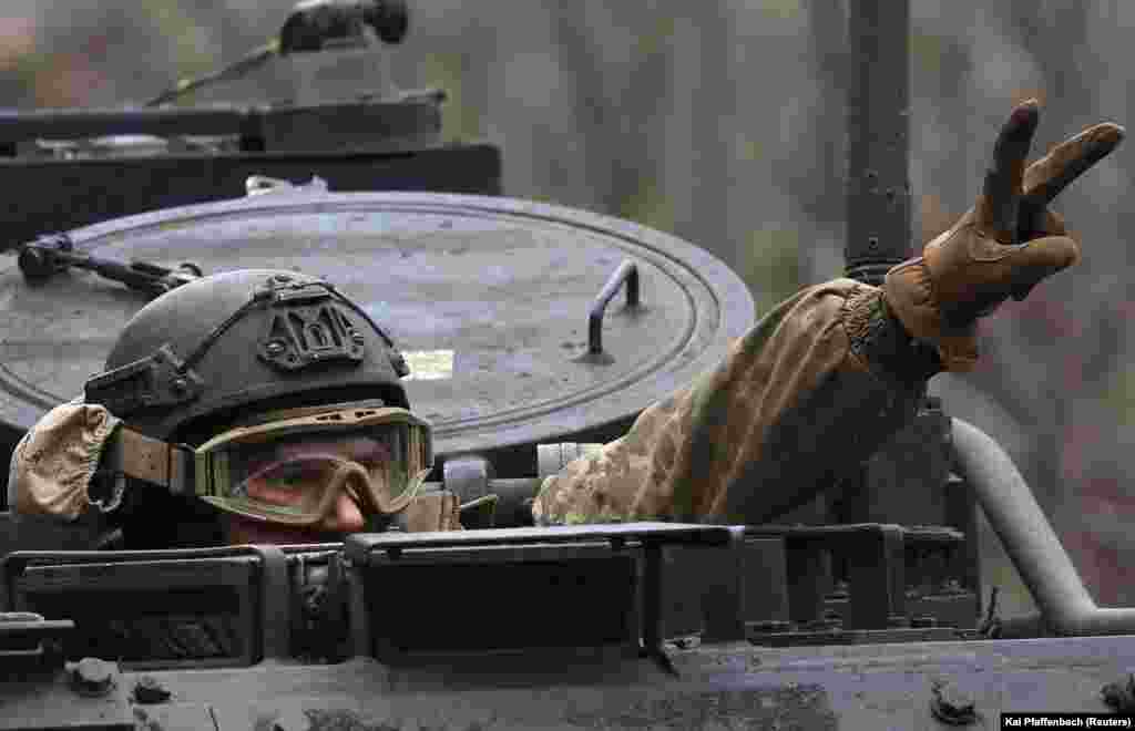 A Ukrainian soldier flashes a victory sign in Chasiv Yar as he drives toward the front line in Bakhmut.
