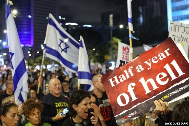 Në tabelën e një protestuesi shkruhet: “Gjysmë viti ferr”. Tel Aviv, 6 prill 2024