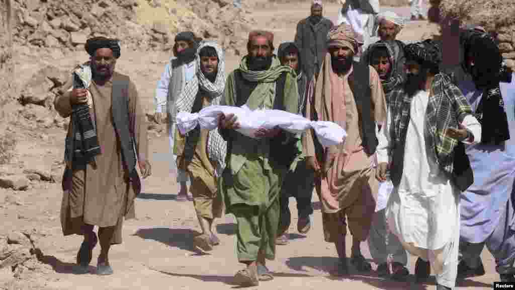 Egy, a földrengés során elhunyt gyermek holttestét viszi apja Szarbuland faluban október 8-án. A segélyszervezetek munkatársai elérték Afganisztán nyugati részén a katasztrófa sújtotta területeket, és megkezdték a sürgősségi élelmiszerosztást. Közben folytatódtak a mentési munkálatok, miután a sorozatos, erős földrengések legkevesebb kétezer ember halálát okozták
