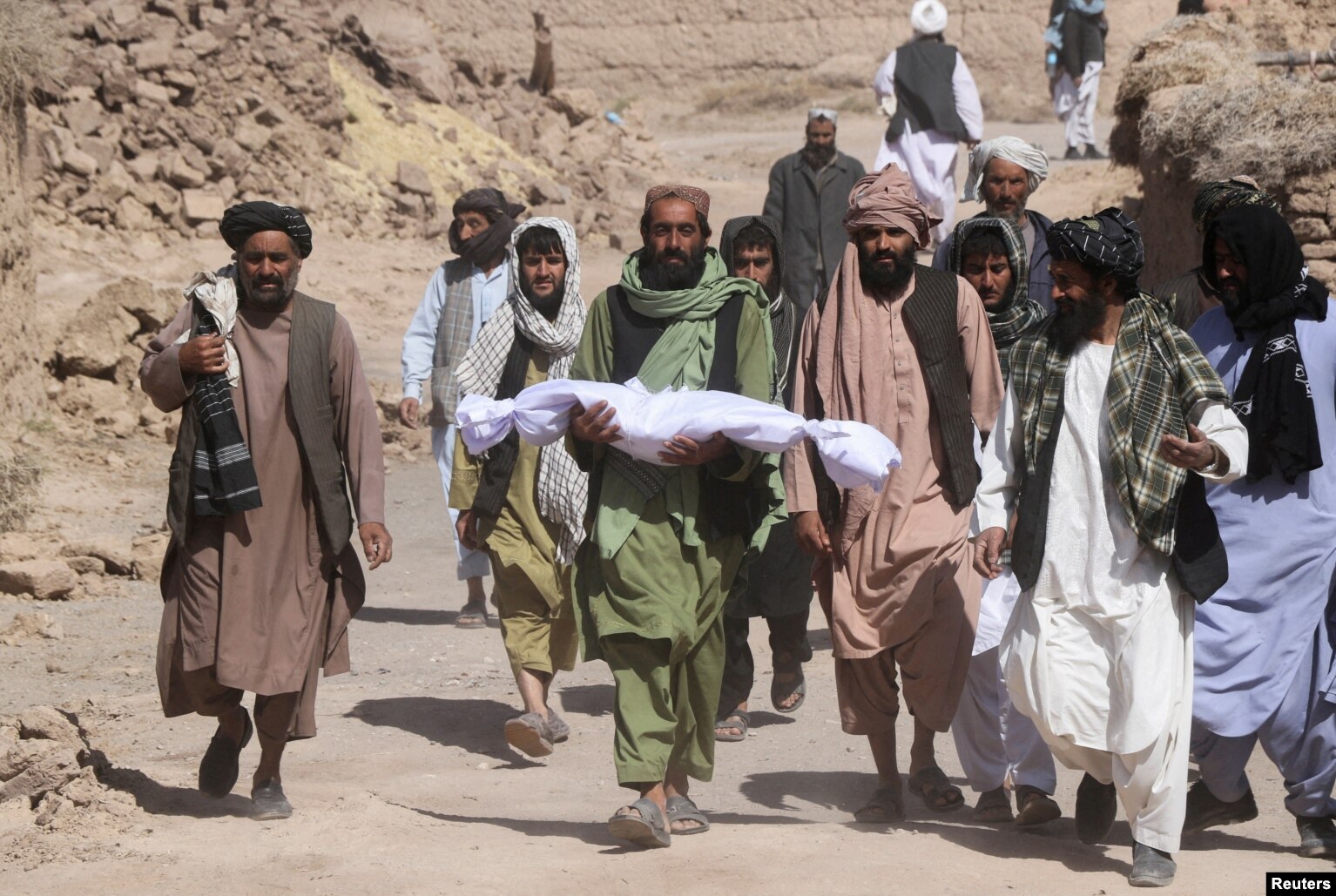 A man carries the lifeless body of his child, who was killed during an earthquake in the village of Sarbuland in Herat Province&#39;s Zindah Jan district on October 8. Aid workers have reached some quake-stricken areas of western Afghanistan and started distributing emergency food supplies to those affected as rescue efforts continued after a series of powerful temblors killed at least 2,000 people.