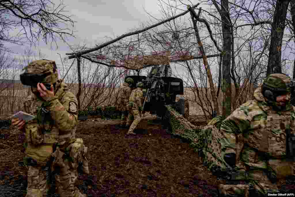 This March 27 photo shows what is becoming an increasingly common sight on the battlefields of Ukraine. The Ukrainian crew firing this Msta-B howitzer near Bakhmut have erected a screen made from chain-link fencing over their weapon. &nbsp;