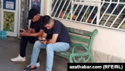 Mobil telefonlaryna seredýän türkmenistanlylar (Illýustrasiýa suraty)