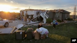 Ljudi iznose stvari iz oštećene kuće u Benningtonu u Nebraski, nakon što je tornado prošao tim područjem u petak, 26. 4. 2024.