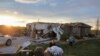 Луѓето носат предмети од оштетениот дом во Бенингтон, Небраска, откако торнадо ја уништи областа во петок, 26 април 2024 година.
