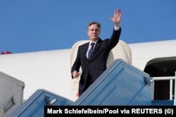 U.S. Secretary of State Antony Blinken waves as he boards his plane at an airport near Tel Aviv on February 8, during his trip to the Middle East