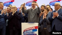 Serbian President Aleksandar Vucic celebrates on stage at the Serbian Progressive Party (SNS) headquarters following exit-poll results of the parliamentary elections in Belgrade on December 17.