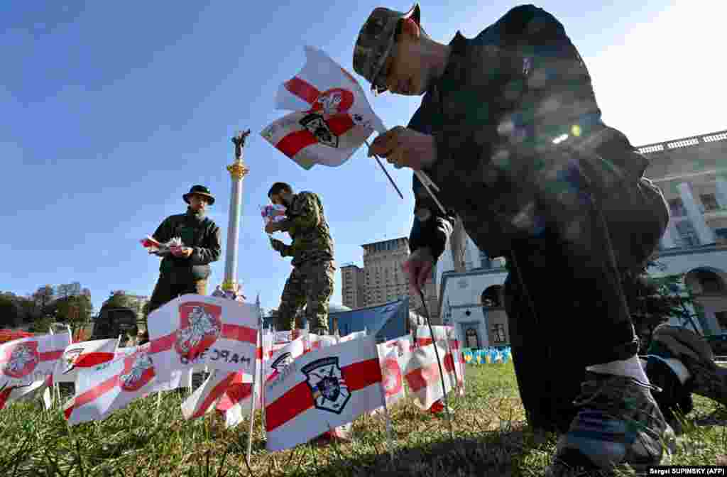 Soldiers from the Volat Battalion of the Belarusian Kastus-Kalynovskiy volunteer regiment plant flags on Independence Square in Kyiv, each of which symbolizes a comrade who died defending Ukraine.