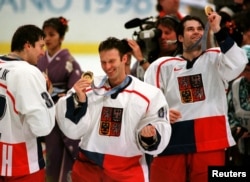 Czech ice hockey goalkeeper Dominik Hasek (center) celebrates winning the Olympic gold with his teammates during the medal ceremony at the Big Hat Stadium in Nagano in February 1998.