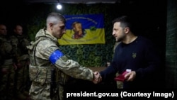 Президент України Володимир Зеленський нагороджує оборонця Харкова під час робочої поїздки до міста. 16 травня 2024 року