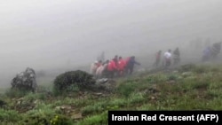 Rescuers recover bodies at the site where a helicopter carrying Iranian President Ebrahim Raisi crashed in a fog-shrouded mountainous area in the country's northwest.