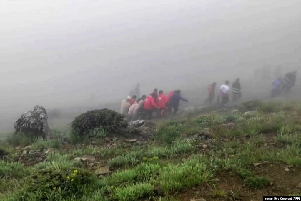 Kjo fotografi e nxjerrë nga një video e publikuar nga Gjysmëhëna e Kuqe iraniane, më 20 maj tregon ekipet e shpëtimit duke bartur trupa nga vendi ku u rrëzua helikopteri, me të cilin po udhëtonte presidenti iranian, Ebrahim Raisi,&nbsp; në një zonë malore të mbuluar me mjegull në veriperëndim të Iranit. Raisi, 63 vjeç, dhe ministri i Jashtëm, Hossein Amir-Abdollahian, janë gjetur të vdekur në vendin e rrëzimit të helikopterit.