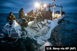 Na ovoj fotografiji koju je je ustupila Mornarica SAD-a, mornari dodijeljeni Grupi za uklanjanje eksplozivnih naprava pronalaze balon za nadzor kod obale Myrtle Beacha, Južna Karolina, 5. februara 2023.