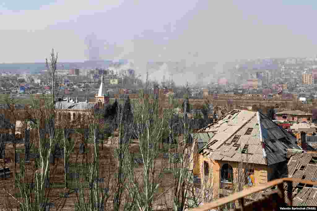 A view over Bakhmut taken from behind Russian lines in eastern Bakhmut on March 24. The image shows smoke rising from the center of the city. In the foreground is Bakhmut&rsquo;s First Baptist Church, and a T-34 tank serving as a World War II memorial (visible at center left).