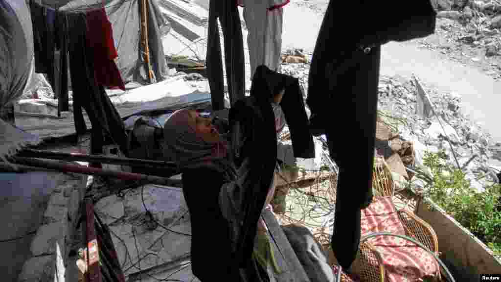 Egy palesztin nő ruhát tereget a Gázai övezet északi részén fekvő Beit Lahiában 2024. június 12-én. Otthonát Izrael katonai offenzívája során rombolták le