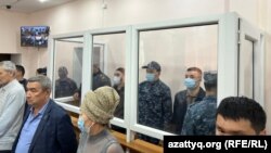 Подсудимые (за стеклом) на заседании суда по делу об убийстве бизнесмена Еркина Мухангалиева, Уральск, 13 апреля 2023 года