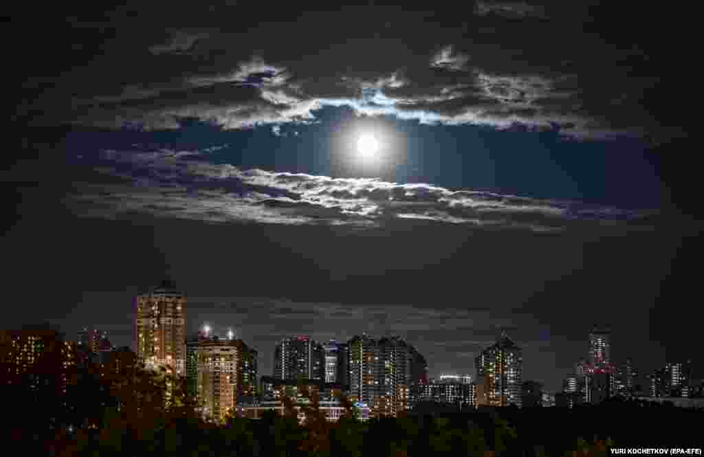 The full moon lights up the sky over buildings in Moscow.&nbsp;