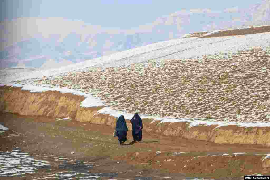 Afghan women walk down a road in Fayzabad.