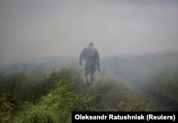 Український військовий йде поблизу звільненого Нескучного, 13 червня 2023 року