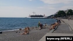 Отдыхающие на пляже в Ялте на фоне заявлений о загрязнении Черного моря после разрушения дамбы Каховского водохранилища в Херсонской области, 16 июня 2023 года