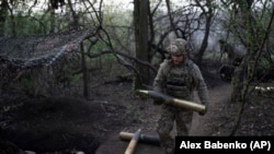 Украинский военнослужащий с артиллерийским снарядом, нехватку которых в последнее время остро испытывали ВСУ