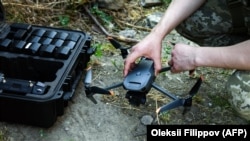Ukrajinski vojnik u Hersonu se priprema za upravljanje komercijalnim dronom DJI Mavic u junu mjesecu.