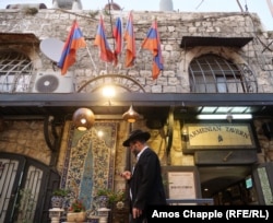 A Jewish man walks past a restaurant in the Armenian Quarter.