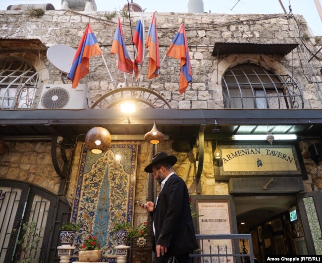 Një burrë duke ecur pranë një restoranti në Lagjen Armene.
