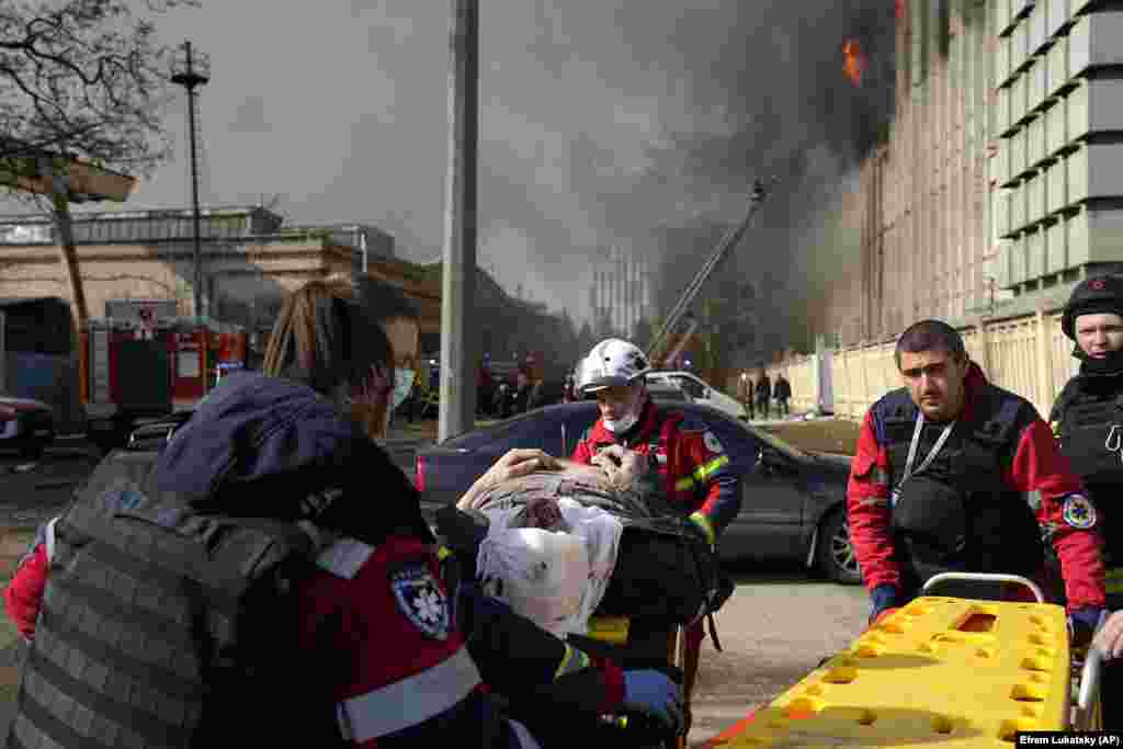 Emergency responders assist a wounded man at the site of a Russian missile attack. The head of the Kharkiv military administration, Oleh Syniehubov, wrote on Telegram that people could still be trapped under the rubble