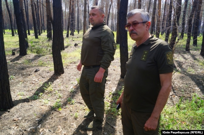 Сергій Олійник (ліворуч) оглядає збитки від військ РФ