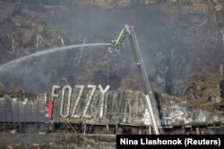 Pompierii ucraineni intervin la un centru comercial distrus în timpul unei lovituri militare rusești, în Odesa, Ucraina, 14 august 2023.