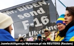 Участники акции в поддержку Украины призывают президента США Джо Байдена предоставить Украине самолеты F-16. Акция проходит у гостиницы Marriott, где Байден остановился во время своего визита в Польшу. Варшава, 22 февраля 2023 года