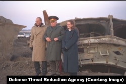 Roland Lajoie (lijevo) i Laura Holgate (desno) iz delegacije američkog ministarstva odbrane poziraju za fotografije s Volodimirom Mykhtyukom, komandantom 43. raketne armije, koja je raspuštena 2002. Trojac stoji uz ostatke raketnog silosa na neimenovanoj lokaciji.