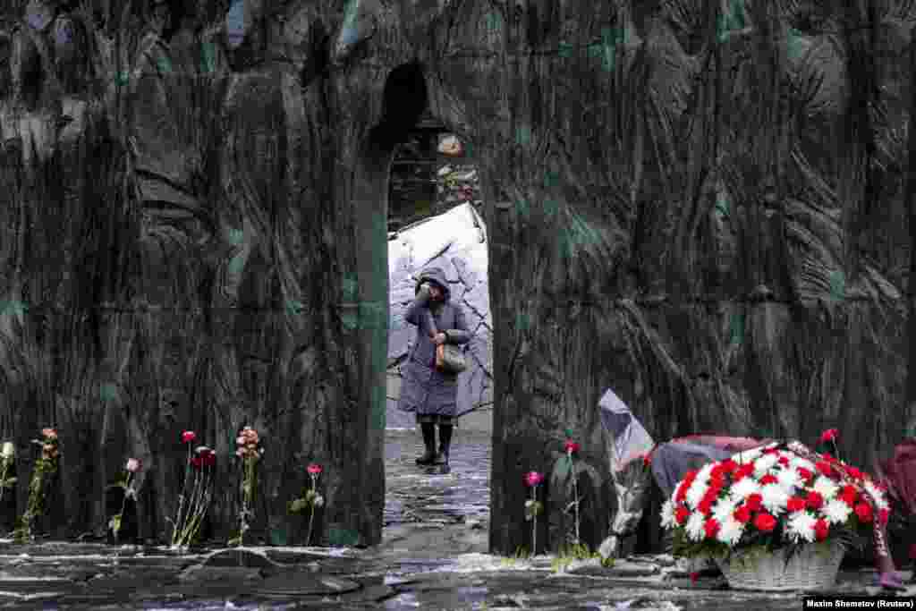 A woman makes the sign of the cross at the Wall of Grief monument on a remembrance day for the victims of political repressions in Moscow on October 30.
