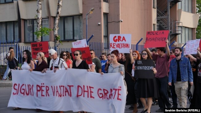 Qytetarët mbajnë një baner me mbishkrimin: "Siguri për vajzat dhe gratë", teksa marshojnë në Prishtinë të hënën më 15 prill, pas vrasjes së një 21-vjeçareje në Ferizaj ditë më parë.