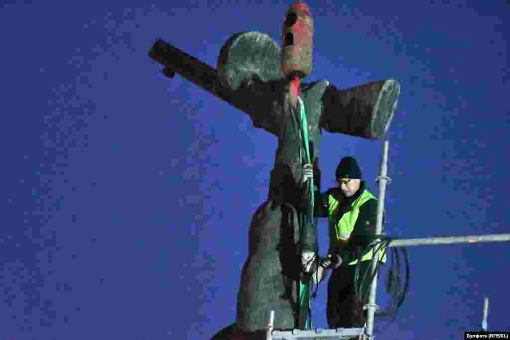 Рабочий готовится к демонтажу части памятника, изображающего оружие советского солдата (пистолет-пулемет ППШ), 12 декабря. Комплекс, прославляющий Красную армию в центре Софии, уже давно вызывал споры в болгарском обществе.